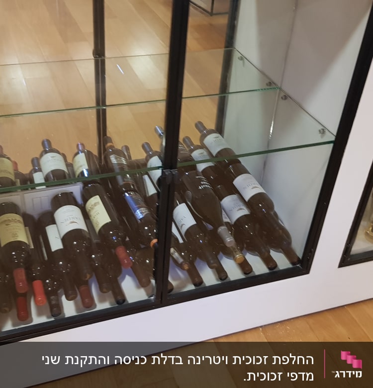 בקבוקי יין מאחורי דלתות זכוכית בארון תצוגה